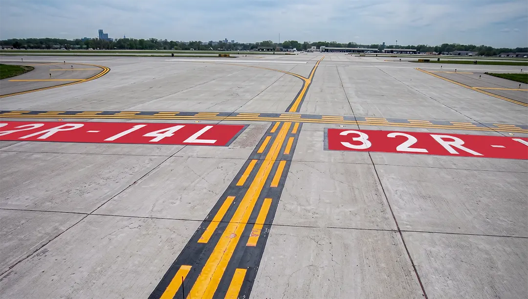 Surface painted runway holding position signs for Runway 32R-14L along with the enhanced taxiway centerline marking