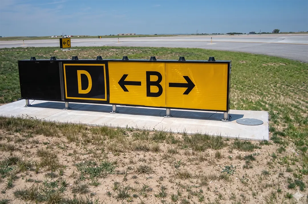 Taxiway Bravo direction sign with a collocated Taxiway Delta location sign. When the arrow on the direction sign indicates a turn, the sign is located prior to the intersection